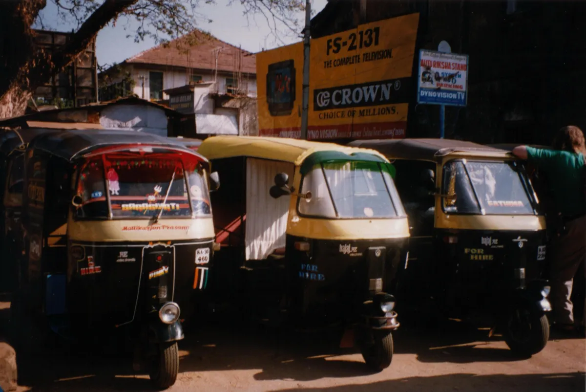 A row of auto rickshaws parked on an Indian street
