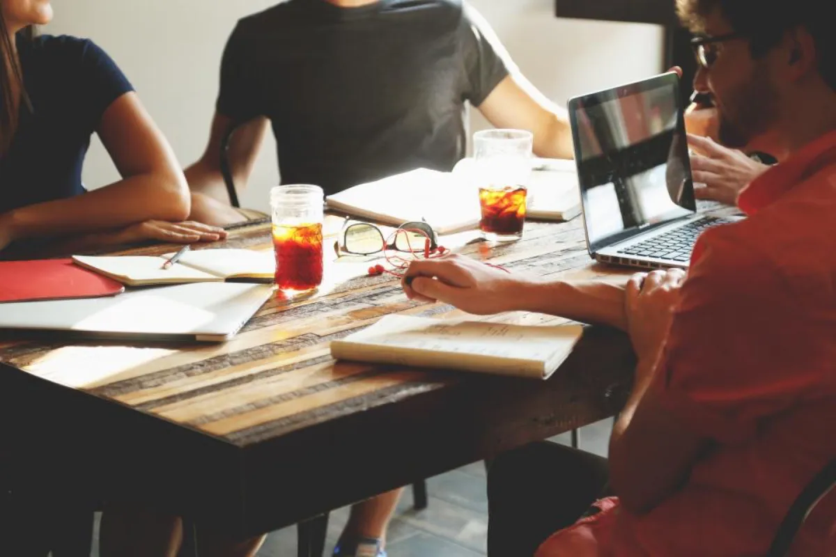 A small team working together around a table with laptops