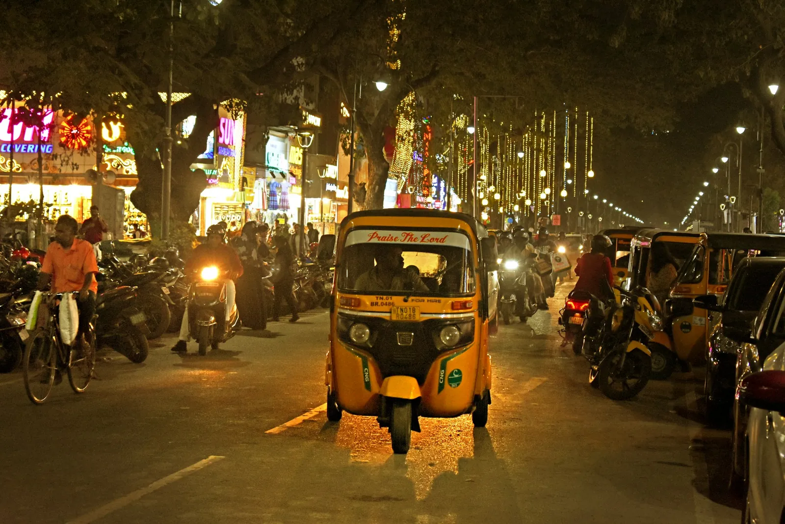Auto-rickshaw on a busy street at night in Chennai